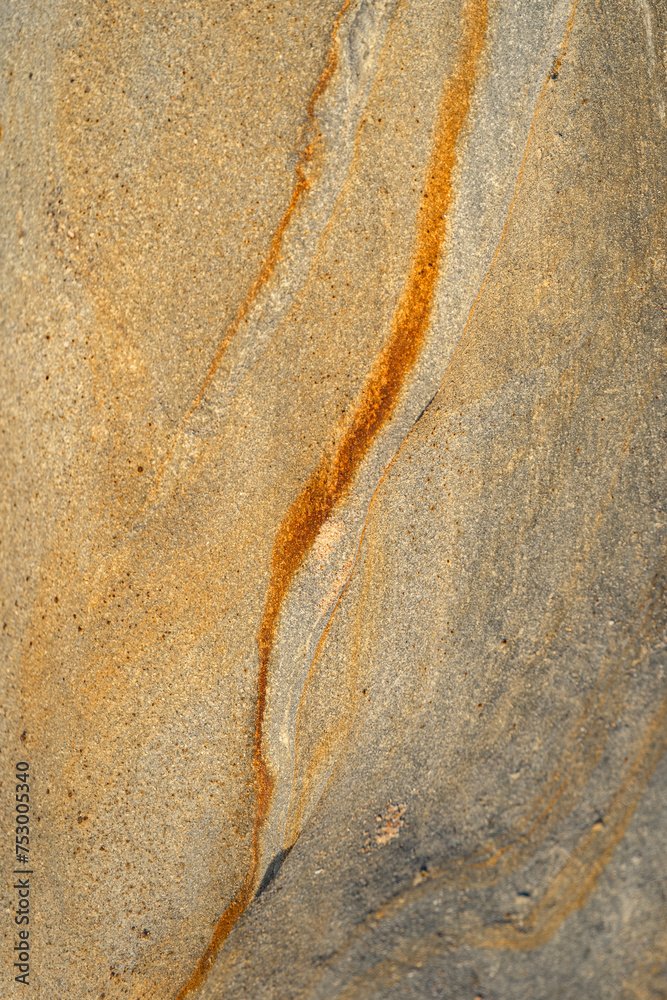 Obraz premium Natural texture background of sandstone rocks with lines, curves, prints in the As Amoeiras and Formosa beach cliffs in Santa Cruz, Portugal.
