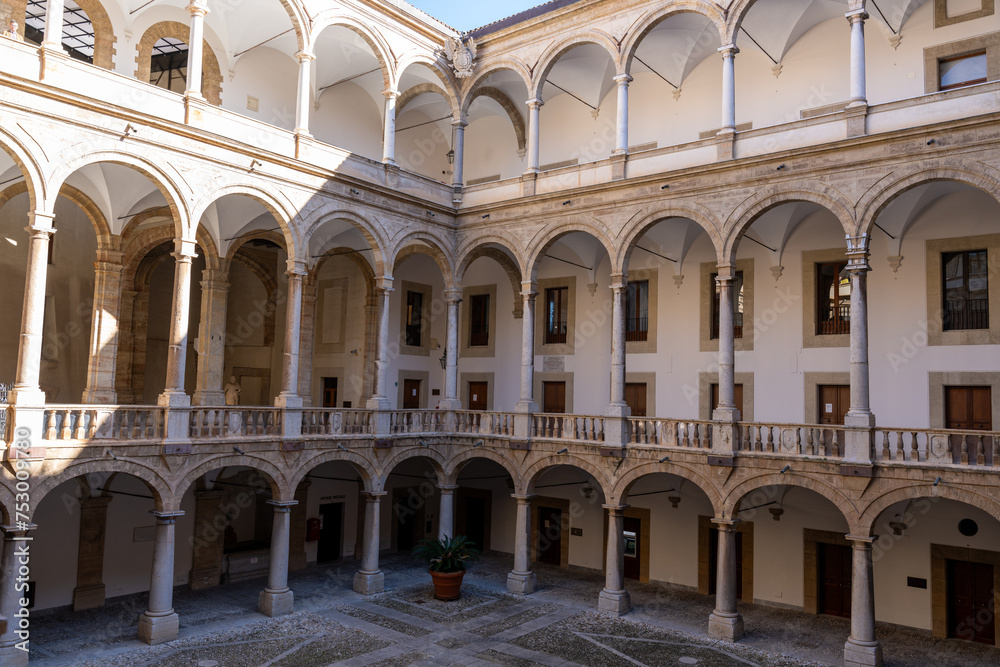 A large open courtyard with arched windows and a balcony