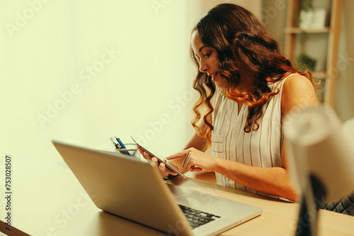 Young business woman in the office works with a tablet