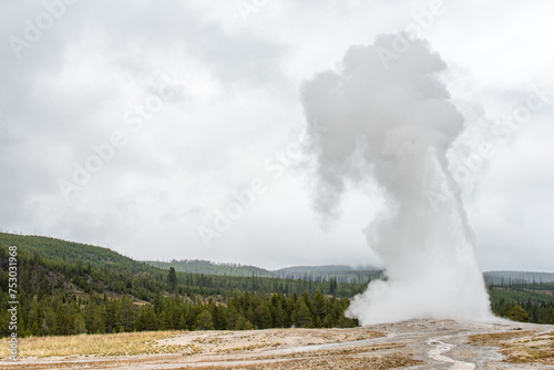 : Old Faithful erupting in Yellowstone National Park during autumn in Wyoming, USA