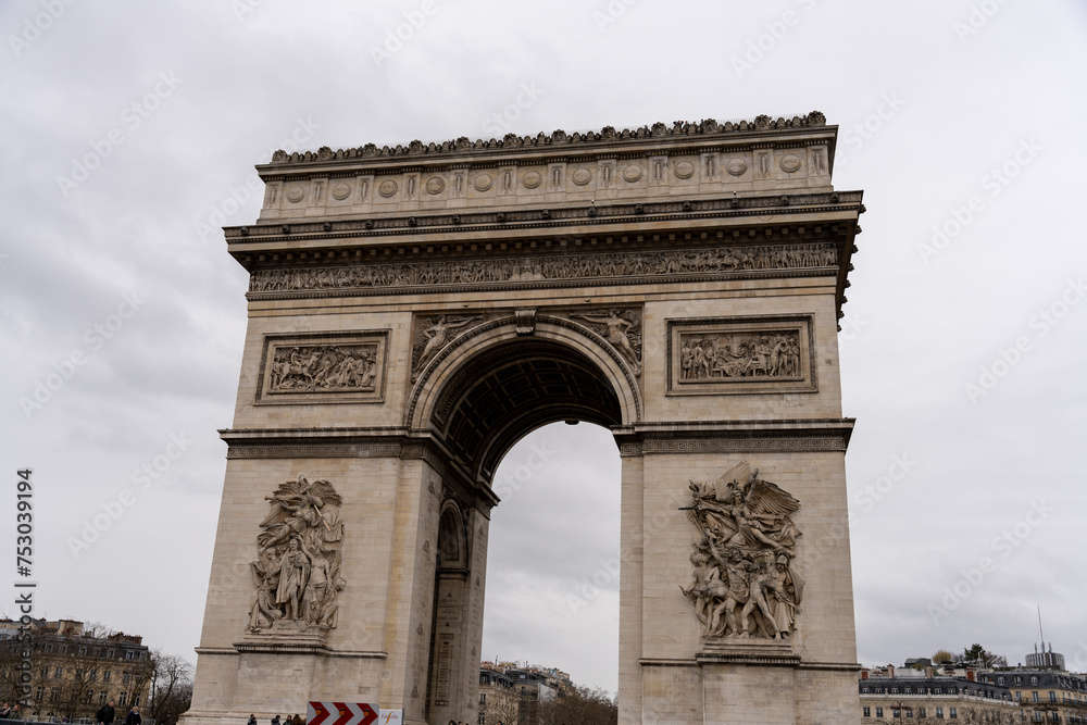 The Arc de Triomphe is a large, white arch with intricate carvings