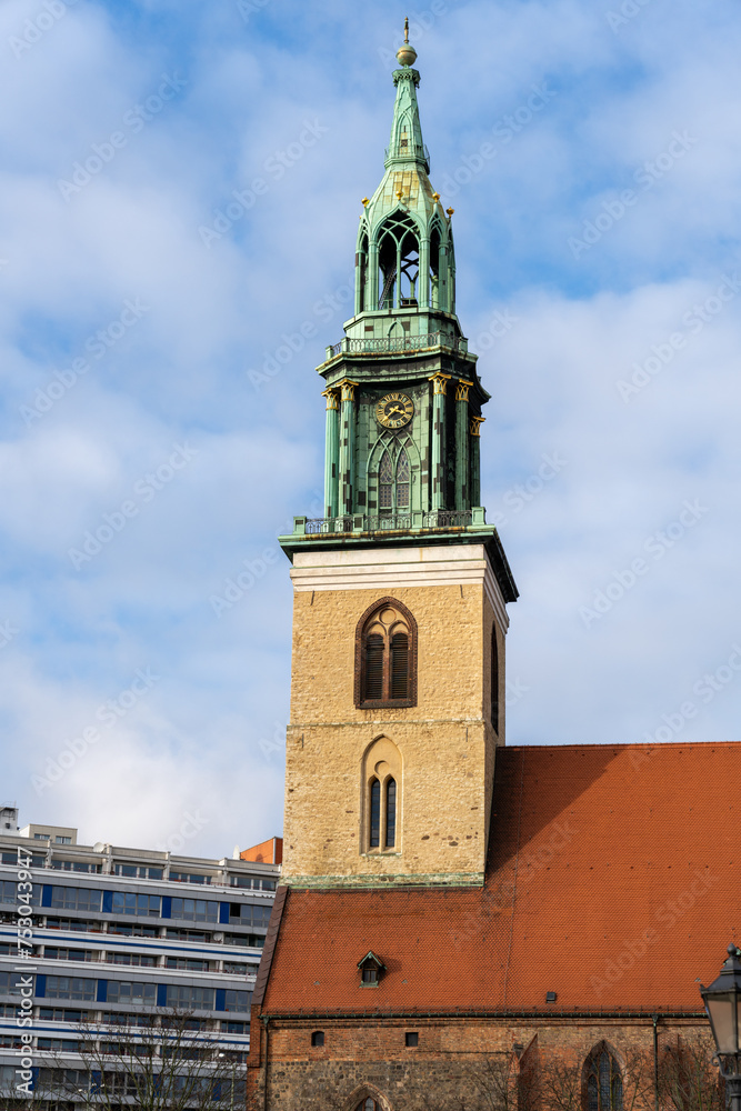 A tall green and brown tower with a clock on it