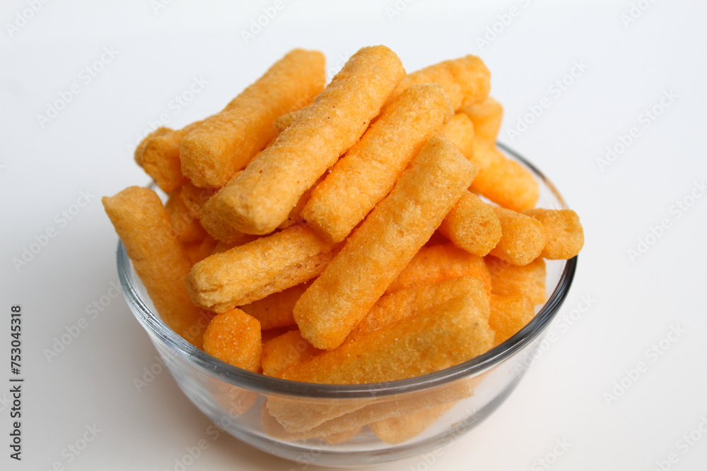 Stik Balado, crackers with savory powder coating. In transparent glass bowl. Isolated on white background Stik Balado, crackers with savory powder coating. In transparent glass bowl. Isolated on white background