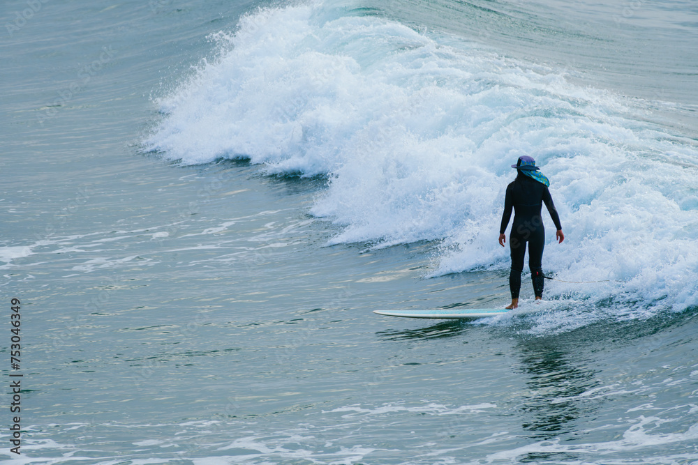 Unrecognizable surfer surfing a calm small wave. Copy space Unrecognizable surfer surfing a calm small wave. Copy space