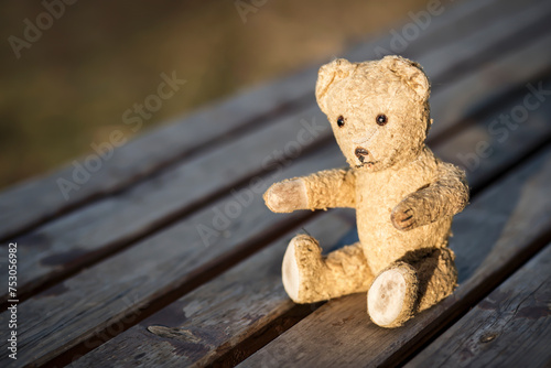 Retro toy bear giving paw for help. Adoption, rescue, hope background.