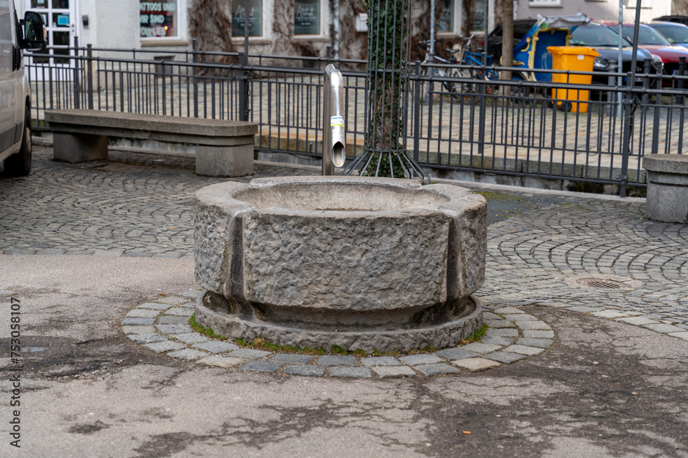 A large stone basin with a pipe sticking out of it