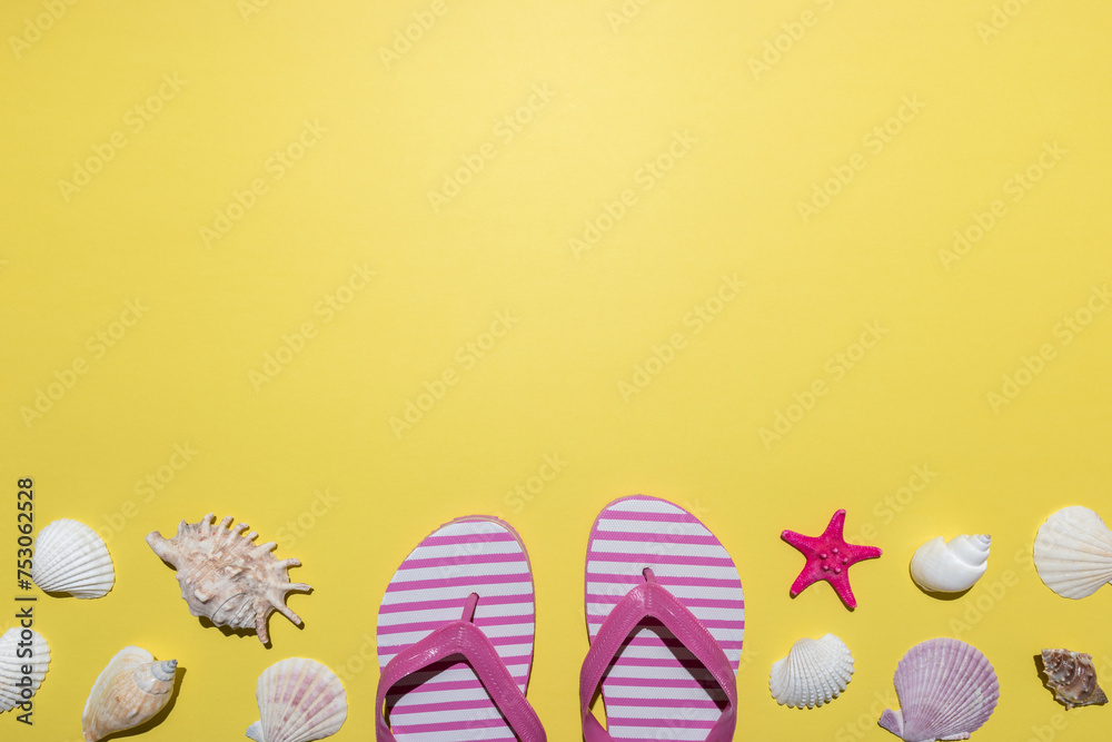 Creative composition with seashells and beach slippers on bright yellow background. Summer minimal concept.