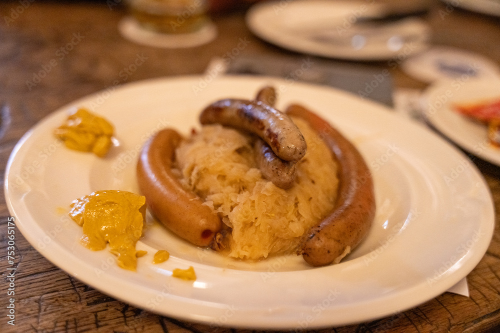 A plate of sausages and mustard sits on a table A plate of sausages and mustard sits on a table