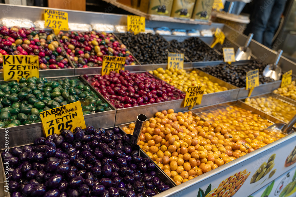 A display of various colored olives for sale