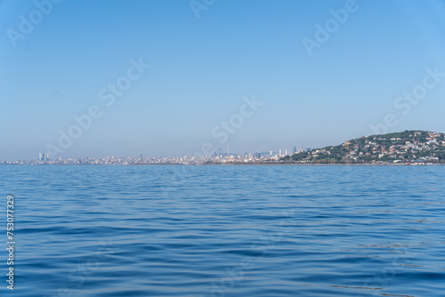 A calm blue ocean with a city skyline in the background