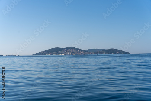 A calm blue ocean with a small island in the distance