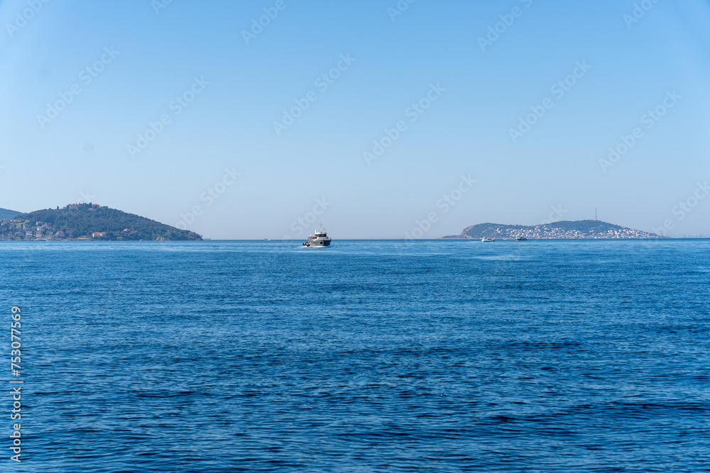 A boat is sailing in the ocean with a clear blue sky in the background