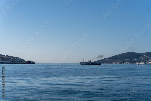 A large ship is sailing in the ocean next to a smaller ship © oybekostanov
