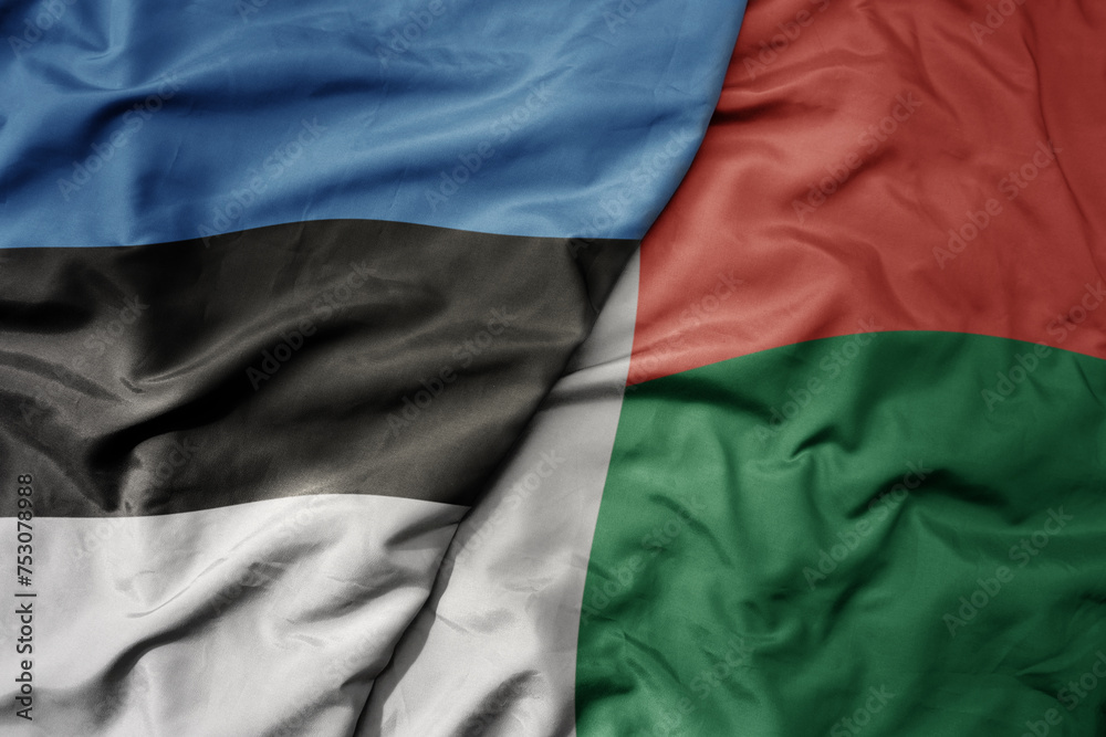 big waving national colorful flag of madagascar and national flag of estonia.