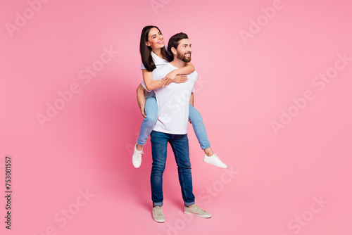 Full length photo of lovely young couple hold piggyback look empty space dressed stylish white garment isolated on pink color background