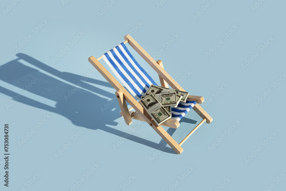 Summer trip planning, sun lounger with money pack, vacation budget, travel discounts Summer trip planning, sun lounger with money pack, vacation budget, travel discounts