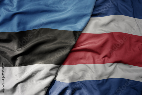 big waving national colorful flag of costa rica and national flag of estonia.
