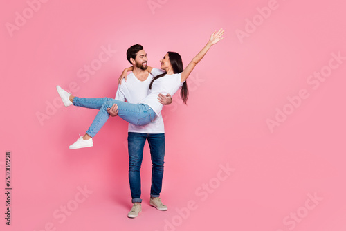 Full length photo of lovely young couple hold carry girlfriend have fun dressed stylish white garment isolated on pink color background