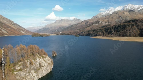 Aerial view of Silsersee lake surrounded by mountains and autumn trees on a sunny day photo