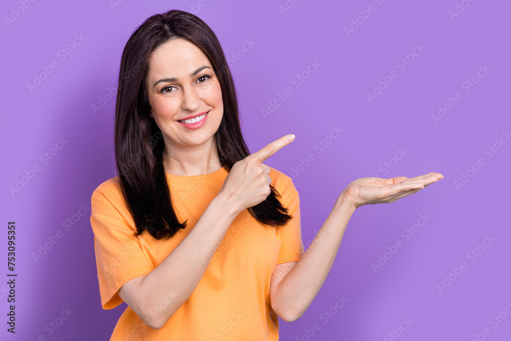 Portrait of attractive businesswoman in yellow t shirt holding pointing finger useful tips create cv isolated on violet color background Portrait of attractive businesswoman in yellow t shirt holding pointing finger useful tips create cv isolated on violet color background
