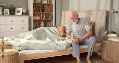 Senior man suffering from knee pain at home