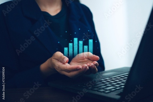Businesswoman uses laptop with virtual world economic growth chart. Economic situation. Investment concepts in the economy.