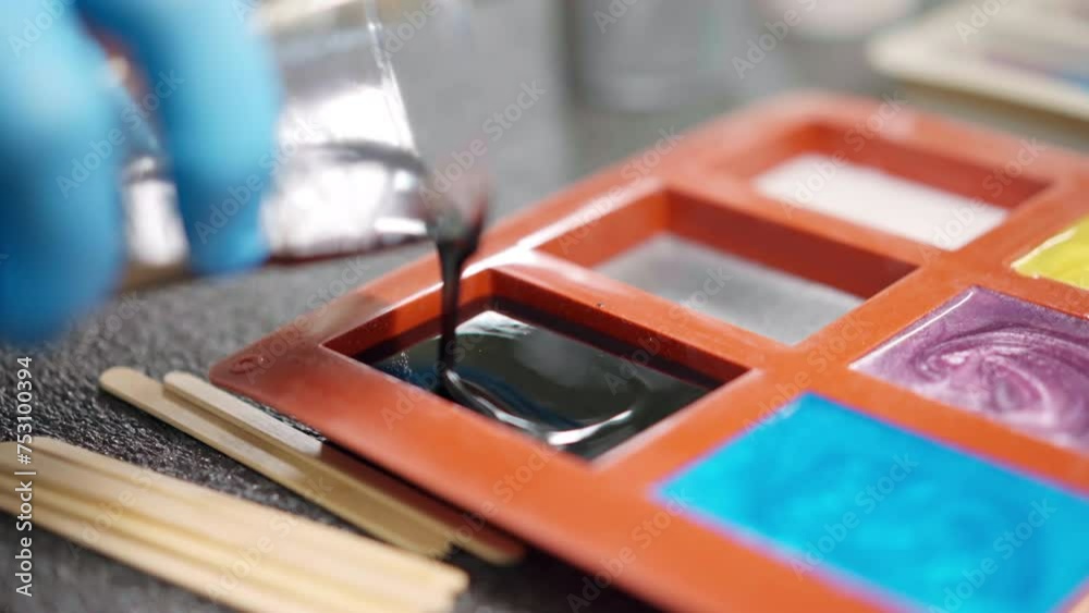 Process of pouring black colour epoxy resin from plastic cup into silicone mold, epoxy resin colours samples formation in carpentry workshop, handmade epoxy design for furniture or accessories Process of pouring black colour epoxy resin from plastic cup into silicone mold, epoxy resin colours samples formation in carpentry workshop, handmade epoxy design for furniture or accessories