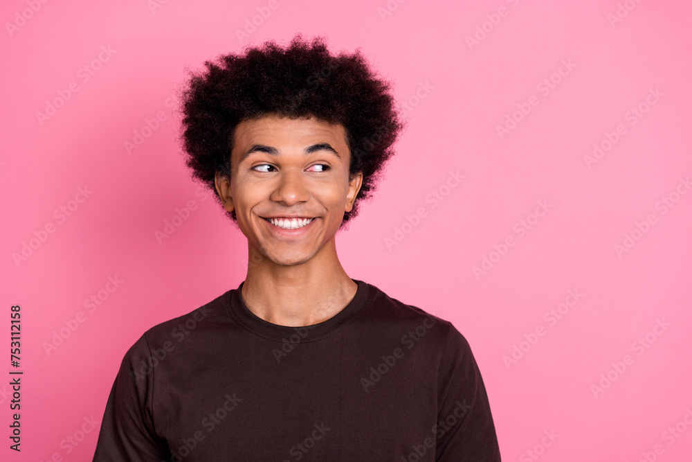 Portrait of cheerful happy young guy in brown t shirt looking empty space discount information advert isolated on pink color background Portrait of cheerful happy young guy in brown t shirt looking empty space discount information advert isolated on pink color background