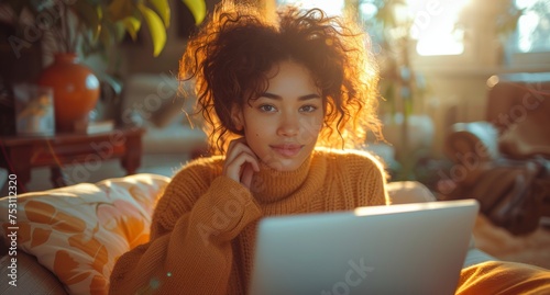 Young woman working on a laptop in a cozy living room, bathed in warm light, exemplifying remote work or relaxation