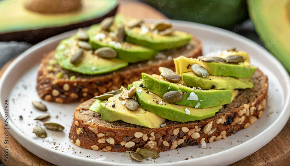 Healthy avocado toasts for breakfast or lunch with rye bread, sliced avocado and pumpkin seeds. Tasty food.