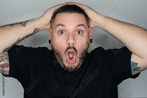 hombre con dilataciones y expresión de sorpresa, hombre con expresión de sorpresa, sorpresa, hombre con piercing y tatuajes expresivo
