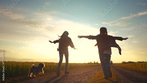 group children and dog running in the park at sunset. happy family freedom a kid dream concept. children kids running along the road in the park in lifestyle nature sunset view from the back