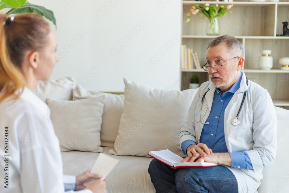 Senior man doctor examining young woman in doctor office or at home. Girl patient and doctor have consultation in hospital room. Medicine healthcare medical checkup. Visit to doctor