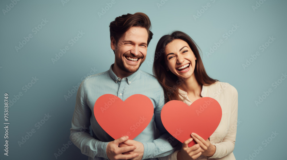 Happy couple holding red hearts celebrating valentine's day