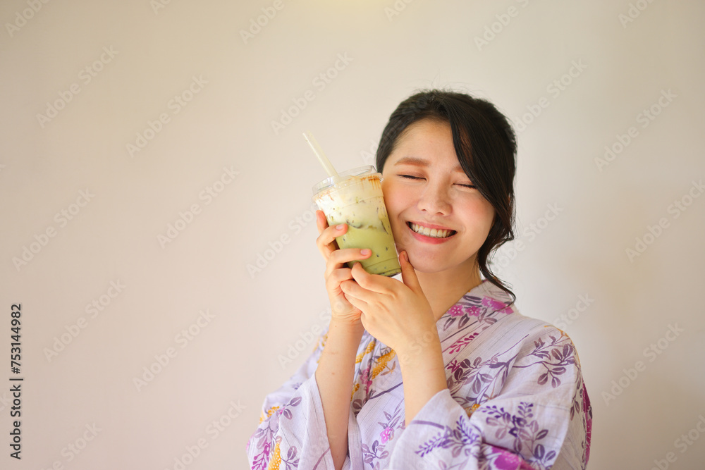Japanese woman with yukata dress and green tea drink in hand