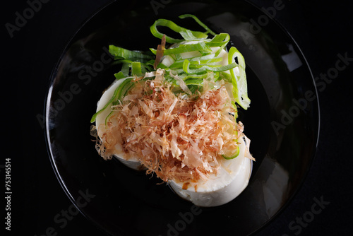Japanese tofu Japanese appetizer soft cold tofu with sauce ginger and green onion topping isolated in black background