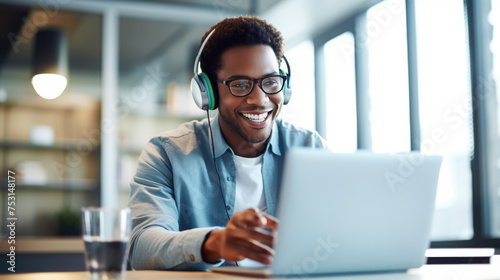 A man in a casual outfit works on a laptop in his office