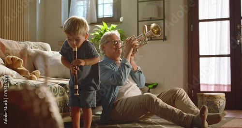 At home, at sunset, the crazy grandfather and his grandson play instruments freely.
Concept of fun, freedom and creativity