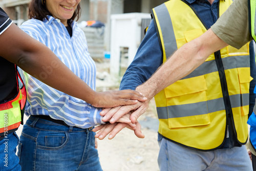 workers joining hands for cooperation success work and project at construction site