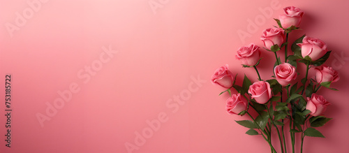 A bouquet of rose flowers placed beside a pink background, copy space