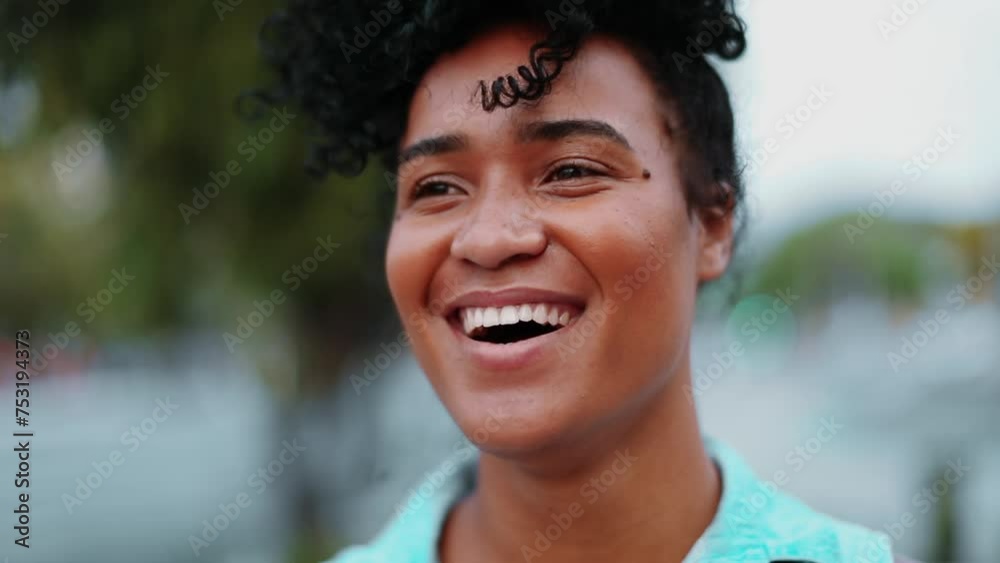 One young happy black Brazilian charismatic woman smiling and laughing standing in urban setting close-up face. 20s person of African descent feeling joy portrait One young happy black Brazilian charismatic woman smiling and laughing standing in urban setting close-up face. 20s person of African descent feeling joy portrait