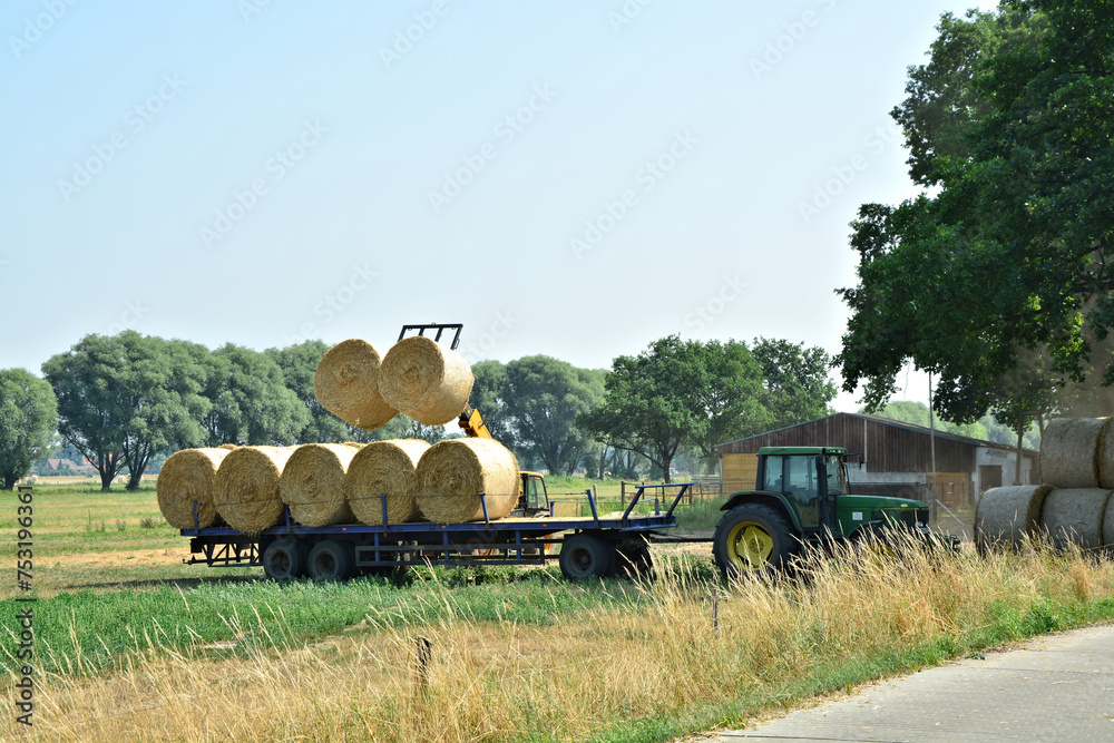 Strohbergung mit Traktor und Kleinbagger Stock Photo | Adobe Stock