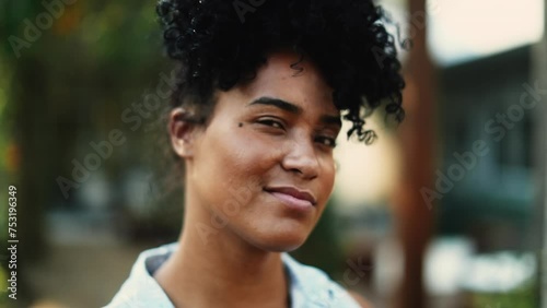 One young black woman winking to camera showing approval. Positive affirmative gesture of wink photo