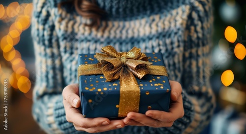 Woman Holding Blue Gift Box With Gold Bow