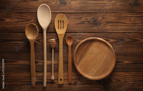 Set of wooden spoons and plate on the table. Kitchen utensils. Flat lay