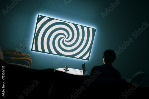 Dark room with a person watching TV with a mesmerizing spiral - manipulation photo