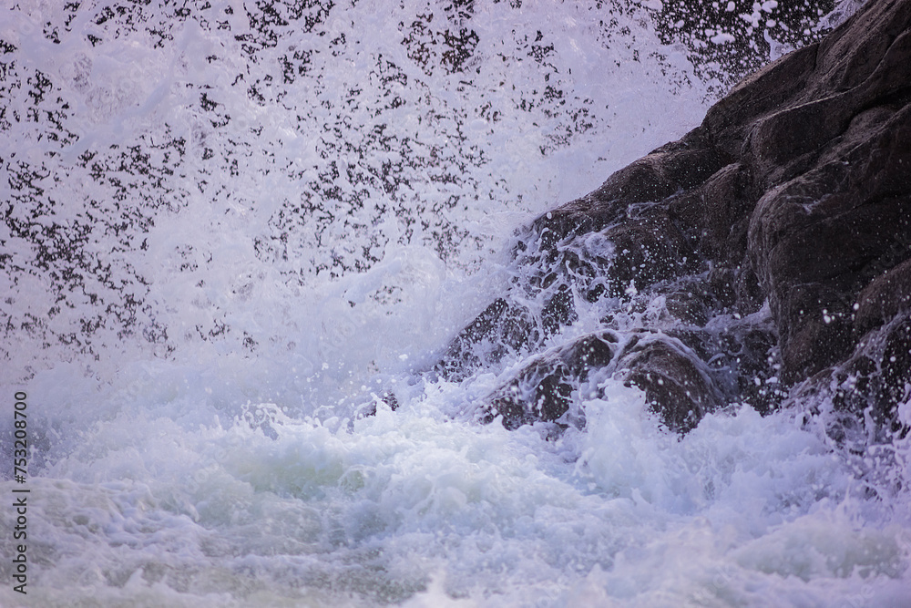 Detail of a wave in the Cantabrian Sea breaking against the rocks of the cliff