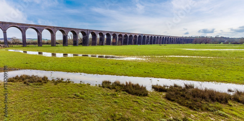 A panorama aerial view across rain soaked fields towards the spectacular Harringworth Viaduct on a bright winter day