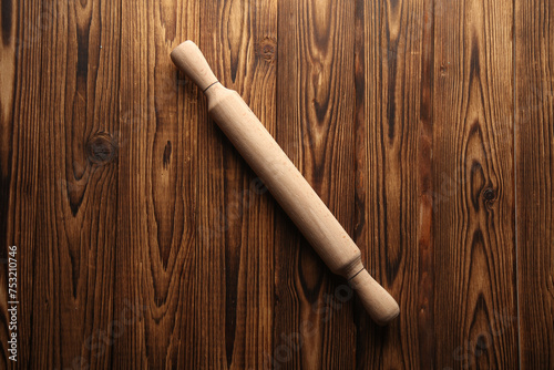 Rolling pin on wooden background. Top view