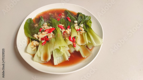 Photos Stir-fry bok coy on a white plate with oyster sauce
